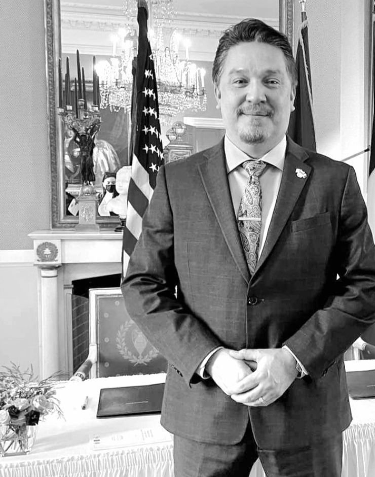 A person standing in front of the American flag, fireplace