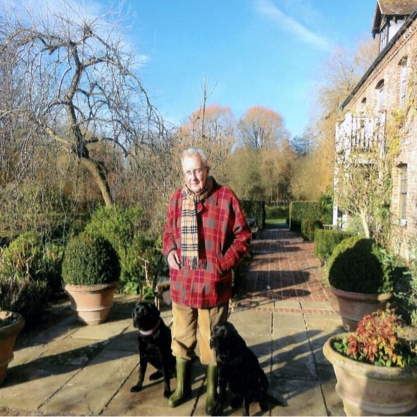 Standing man with two dogs in garden setting